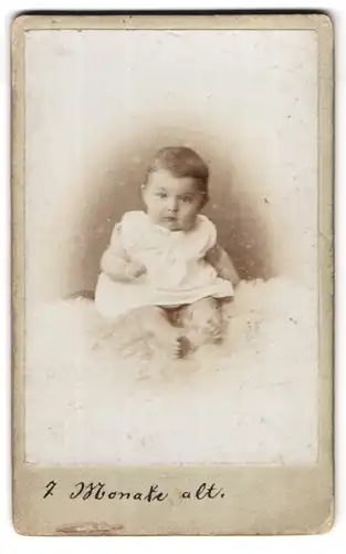 Fotografie unbekannter Fotograf und Ort, Portrait niedliches Kleinkind im weissen Hemd mit nackigen Füssen