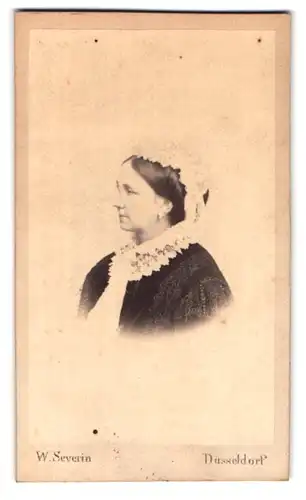 Fotografie W. Severin, Düsseldorf, Portrait Frau im reich bestickten Kleid mit Rüschenhaube