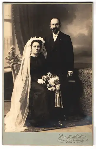 Fotografie Rudolf Müller, Görlitz, Portrait älteres Brautpaar im dunklen Kleid mit Schleier und Anzug mit Zylinder