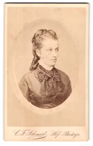 Fotografie C. F. Schmid, Reutlingen, Portrait Frau im glänzenden Kleid mit Zöpfen