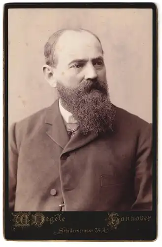 Fotografie W. Degèle, Hannover, Schillerstr. 34a, Portrait Mann im Anzug mit Vollbart und Halbglatze