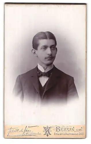 Fotografie Achill de Veer, Berlin-SW, Friedrichstrasse 247, Portrait junger Mann im Anzug mit Fliege