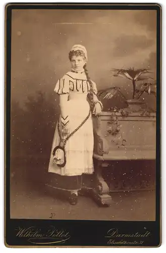 Fotografie Wilhelm Pöllot, Darmstadt, Elisabethenstr. 31, Portrait junge Frau im Fasching Kostüm lehnt an einer Bank