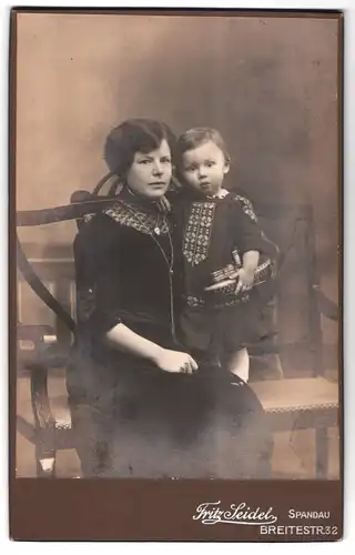 Fotografie Fritz Seidel, Spandau, Breitestr. 32, Portrait Mutter mit Kind und Blechspielzeug Schiff Dampfer