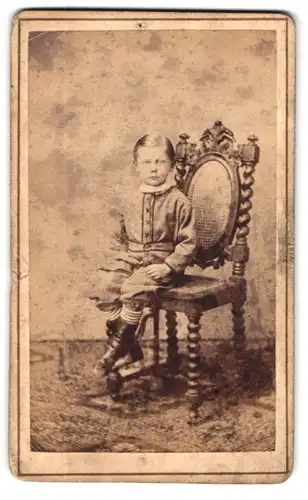 Fotografie Th. Molsberger, Arolsen, Portrait hübsch gekleideter Junge auf Stuhl sitzend
