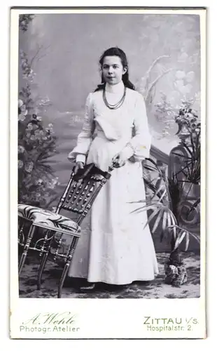 Fotografie A. Wehle, Zittau i / S., Hospitalstrasse 2, Portrait junge Dame im weissen Kleid mit Stuhl