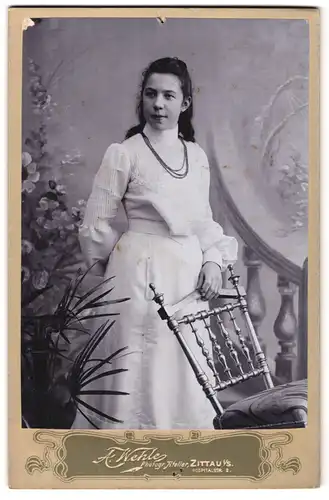 Fotografie A. Wehle, Zittau i / S., Hospitalstrasse 2, Portrait junge Dame im weissen Kleid mit einem Stuhl