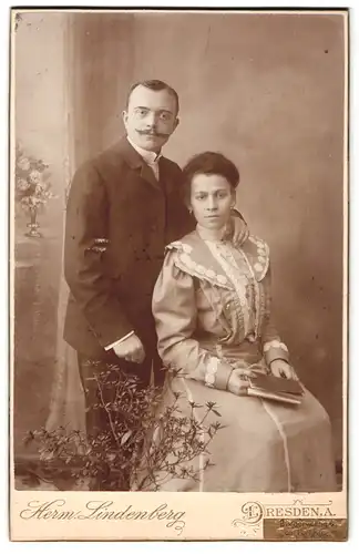 Fotografie Herm. Lindenberg, Dresden-A, Bürgerwiese 6, Portrait junges Paar in modischer Kleidung mit Buch