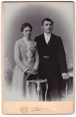 Fotografie A. Rehmke, Kiel, Preusserstrasse 5, Portrait junges Paar in eleganter Kleidung mit Buch