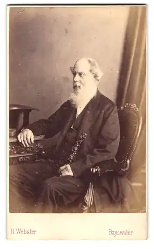 Fotografie H. Webster, Bayswater, Portrait alter Mann im Anzug mit Vollbart und Spazierstock