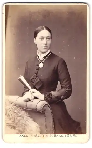 Fotografie T. Fall, London, 9 / 10 Baker Street, Portrait junge Frau im züchtigen Kleid mit Fächer und Halskette