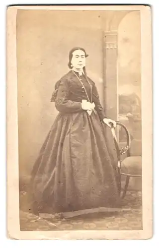 Fotografie L. Phillips, London, 304 Regent Street, Portrait Dame im Biedermeier Kleid mit Kette vor Studiokulisse