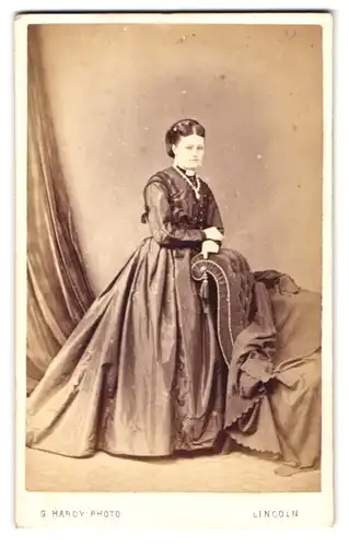 Fotografie G. Hardy, Lincoln, 1 Norman Place, Portrait junge Frau im seidenen Kleid mit Kette und Hochsteckfrisur