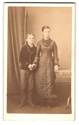 Fotografie Walter S. Dexter, Wellingboro, 44 Midland Road, Portrait Mutter mit Sohn, züchtiges Kleid mit Perlen Ketten