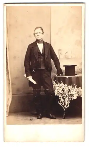 Fotografie Jackson Bros., Oldham, Portrait älterer Herr im schwarzen Anzug mit Zylinder, Halstuch