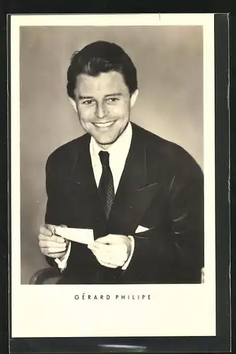 AK Schauspieler Gérard Philipe hält eine Autogrammkarte in der Hand