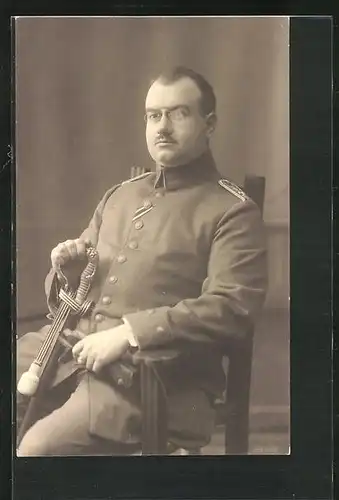 Foto-AK Sitzender Soldat in Uniform mit Brille