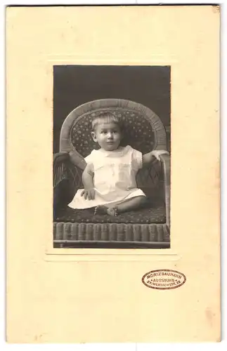 Fotografie Moriz Baumann, Augsburg, Wertachstrasse 27, Portrait niedliches Kleinkind im weissen Kleid auf Stuhl sitzend