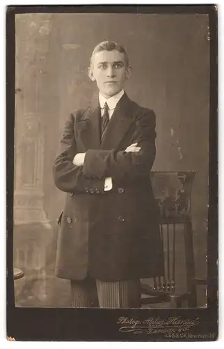 Fotografie Atelier Hansa G. m. b. H., Lübeck, Breitestrasse 39, Portrait eleganter Herr mit verschränkten Armen