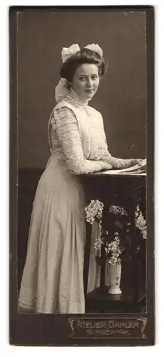 Fotografie Atelier Dahlem, Bingen a / Rh., Portrait modisch gekleidete Dame mit Foto in der Hand