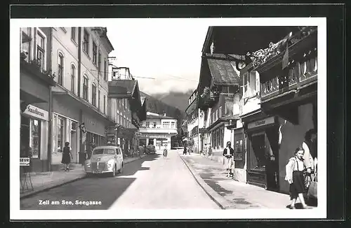 AK Zell am See, Seegasse mit Geschäften, Passanten und Oldtimern