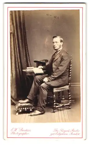 Fotografie E. W: Proktor, London, 90 Edgware Road, Portrait junger Mann im Anzug mit Zylinder und Shin-Strap Bart