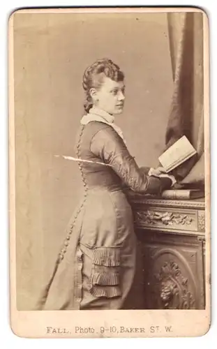 Fotografie T. Fall, London, 9-10 Baker St., Portrait junge Frau im engen Kleid mit Zopf