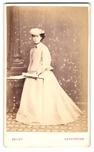 Fotografie H. Bailey, Kensington, 4 Newland Terrace, Portrait junge Dame im weissen Kleid mit Jacke und Hut