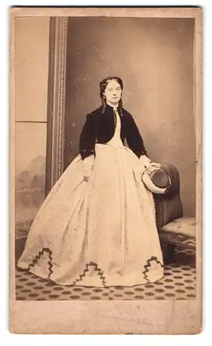 Fotografie Lupson, Stoke Newington, Church Street, Portrait junges Mädchen im Reifrockkleid mit Zopf und Hut