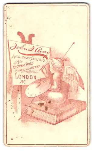 Fotografie John J. Avery, London, 7 Archway Road, Engel sitzt auf Buch und malt Logo auf eine Staffelei