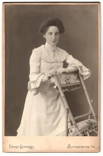 Fotografie Ernst Schinkel, Blankenburg a / H., Mauerstrasse 3, Portrait hübsch gekleidete Dame mit einem Stuhl