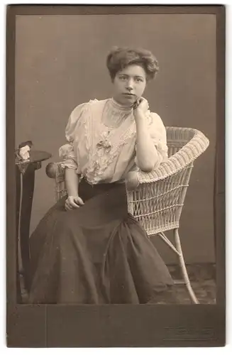 Fotografie R. Werner, Hamburg, Neuerwall 34, Portrait junge Dame in hübscher Bluse auf Korbstuhl sitzend