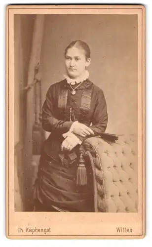 Fotografie Th. Kaphengst, Witten, Bahnhofstrasse, Portrait bürgerliche Dame mit Fächer an Sessel gelehnt