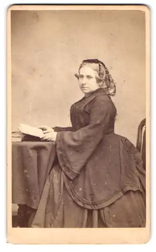 Fotografie Henry Death, London, 119 Camberwell Road, Portrait Frau im Reifrockkleid mit Zöpfen