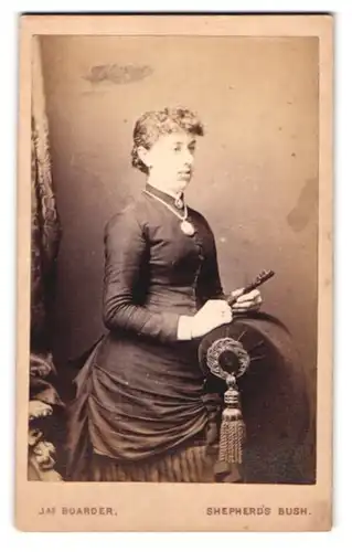 Fotografie Jas. Boarder, London, 332 Uxbridge Road, Portrait junge Frau im züchtigen Kleid mit Locken