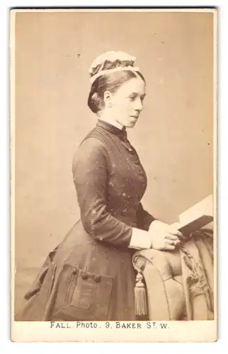 Fotografie T. Fall, London, 9 Baker Street, Portrait junges Frau im züchtigen Kleid mit Haube liest ein Buch