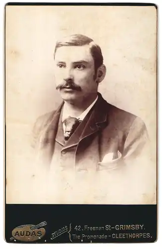 Fotografie AUDAS Studios, Grimsby, 42 Freeman St., Portrait junger Mann im Anzug mit Krawatte und Moustache