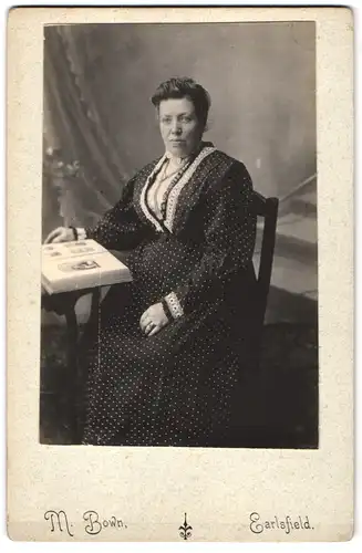 Fotografie M. Bown, Earlsfield, Portrait bürgerliche Dame mit Album am Tisch sitzend