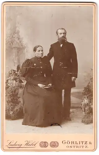 Fotografie Ludwig Habel, Görlitz, Breitestrasse 16, Portrait bürgerliches Paar in eleganter Kleidung mit Buch