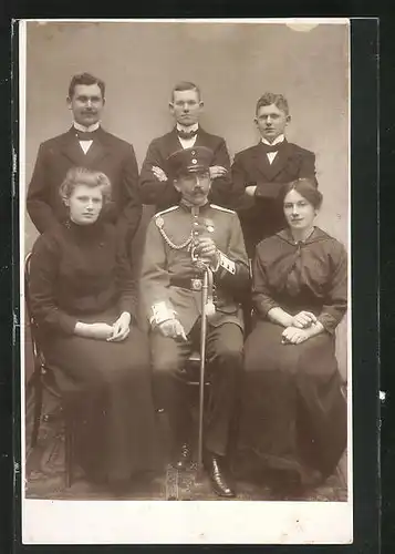 Foto-AK Soldat in Uniform mit Schirmmütze im engen Kreis, Uniformfoto