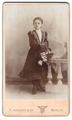 Fotografie A. Jandorf & Co., Berlin-C, Spittelmarkt 16-17, Portrait modisch gekleidetes Mädchen mit Blumenkorb