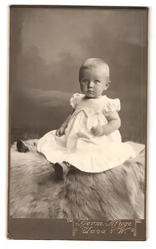Fotografie Hermann Kluge, Unna i / W., Schäferstrasse 14, Portrait kleines Mädchen im weissen Kleid auf Fell sitzend
