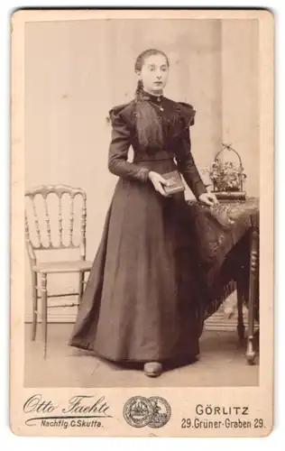 Fotografie Otto Fachte, Görlitz, Grüner Graben 29, Junge Dame mit geflochtenen Haaren trägt Kleid und hält Buch