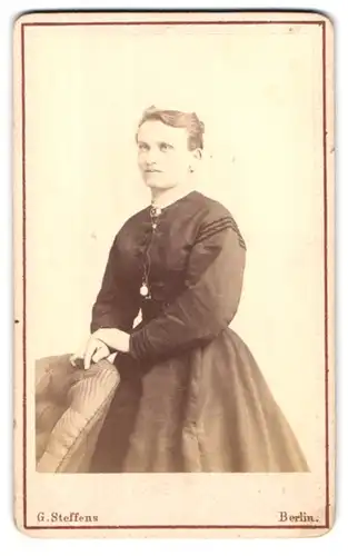 Fotografie G. Steffens, Berlin, Potsdamerstr. 116a, Dame im eleganten schwarzen Kleid mit Halskette & Anhänger