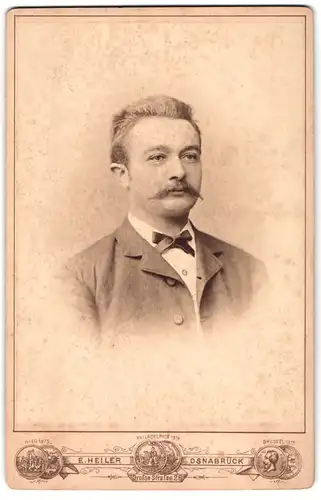 Fotografie E. Heiler, Osnabrück, Portrait junger Mann im grauen Anzug mit Fliege und Moustache