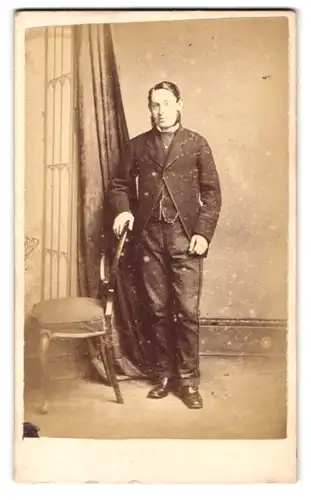 Fotografie Stuart Brothers, London, 47 Bromton Road, Portrait Herr im Anzug mit Nadelstreifenhose, Backenbart