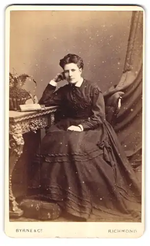 Fotografie Byrne & Co., Richmond, Hill Street, Portrait junge Frau im dunklen Kleid mit Zopf