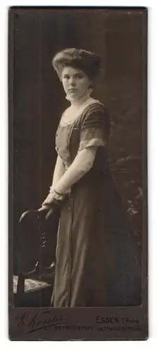 Fotografie E. Kessler, Essen a. Ruhr, Kettwiger-Str. 39, Portrait junge Frau im Jungedstilkleid mit toupierten Haaren