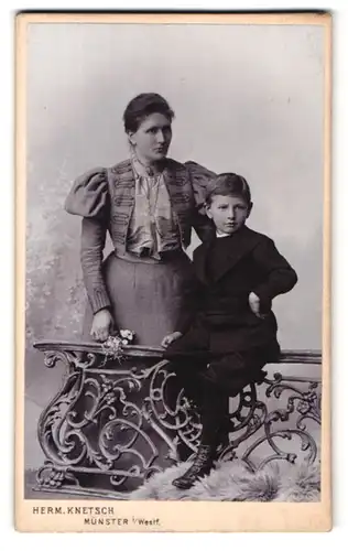 Fotografie Herm. Knetsch, Münster i. Westf., gegenüber dem Bahnhof, Portrait Mutter im Bolero mit Puffärmeln und Sohn im