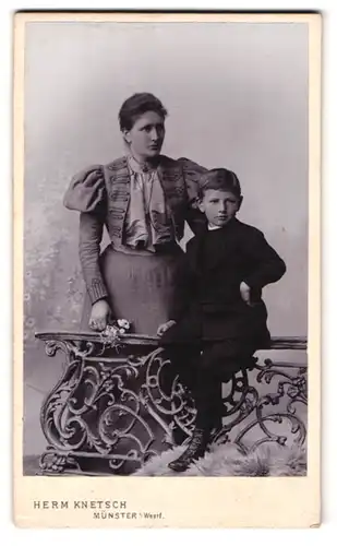 Fotografie Herm. Knetsch, Münster i. Westf., gegenüber dem Bahnhof, Portrait Mutter mit Sohn trägt Rock und Bolero